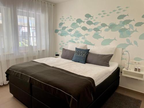 a bedroom with a large bed with a green and gray patterned wall at Appartementanlage Lancken-Granitz in Lancken-Granitz