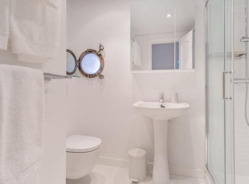 a white bathroom with a toilet and a sink at LAGASCA V in Madrid