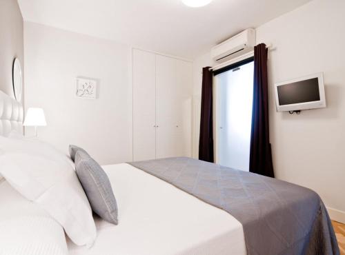 um quarto branco com uma cama e uma janela em Princesa V em Madri