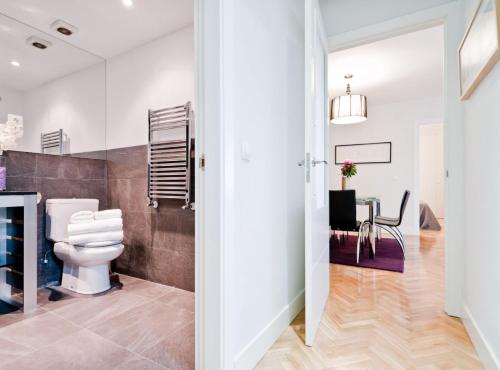 a bathroom with a toilet and a dining room at Princesa V in Madrid