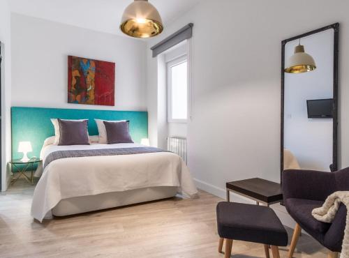 een slaapkamer met een groot bed en een spiegel bij Claudio Coello I in Madrid