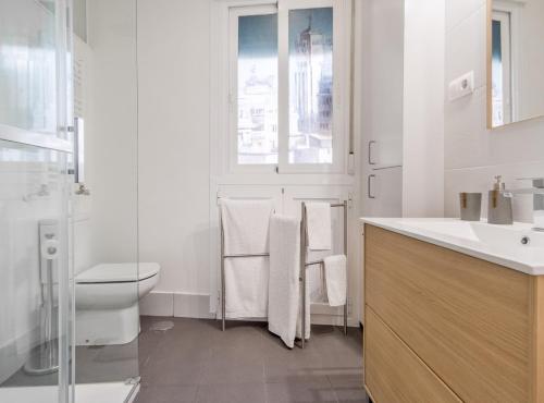 een witte badkamer met een toilet en een wastafel bij Claudio Coello I in Madrid