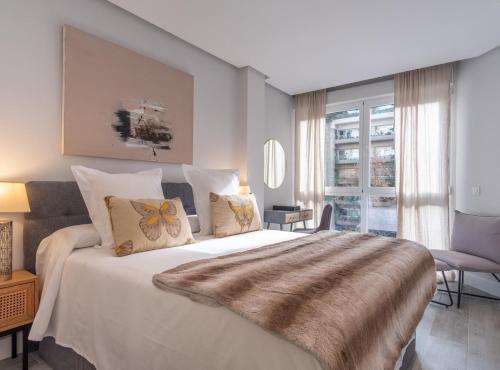 a bedroom with a large white bed and a window at Alberto Aguilera I in Madrid