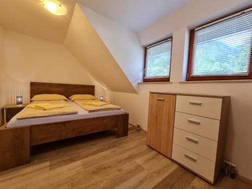 a bedroom with a bed and two windows at Apartments Irena in Bohinj