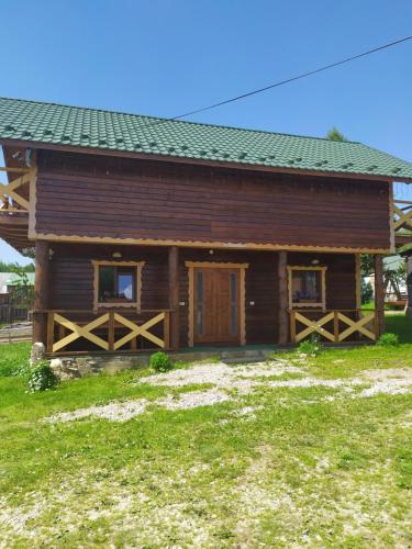 a log cabin with a green roof at Dobryi Hutsul 2 in Mykulychyn