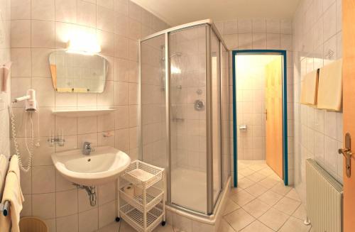y baño con ducha y lavamanos. en Hotel Krone, en Oberperfuss