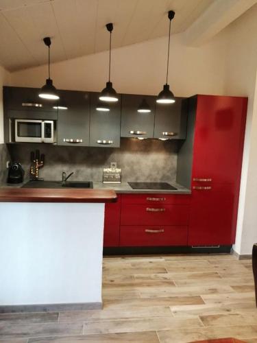 une cuisine avec des armoires rouges et un évier dans l'établissement villa les lauriers, à Porto-Vecchio