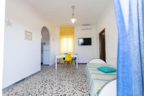 a bedroom with a bed and a table with a yellow chair at Puntamare in Peschici