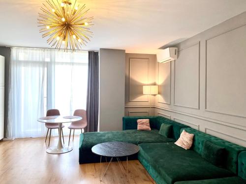a living room with a green couch and a table at Velvet Home in Timişoara