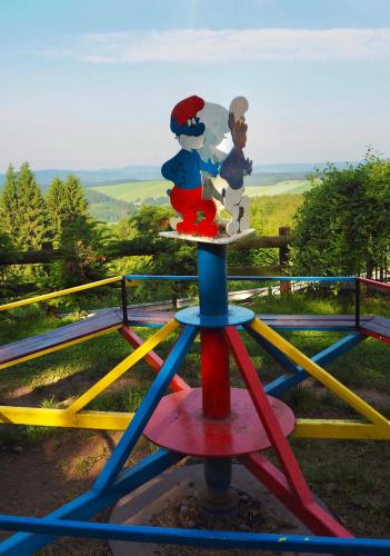 a colorful play structure with two people on it at Penzion Vyhlídka Janovičky in Broumov