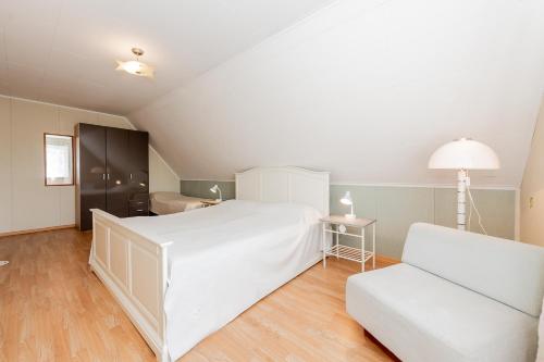 a bedroom with a large white bed and a chair at Lubja Holiday House in Pärnu