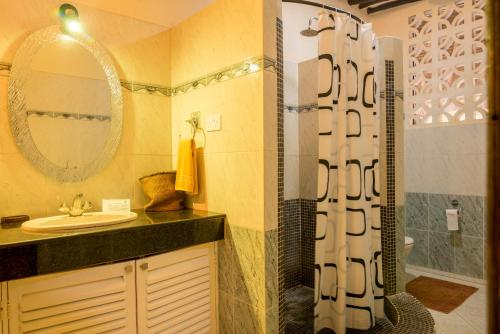 a bathroom with a shower and a sink at Upani in Diani in Diani Beach
