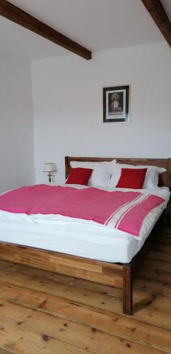 a bedroom with a large bed with a red blanket at Le Derrien in La Roche-Derrien