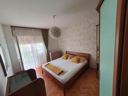 a small bedroom with a bed and a window at Apartment Sladojevic in Omiš