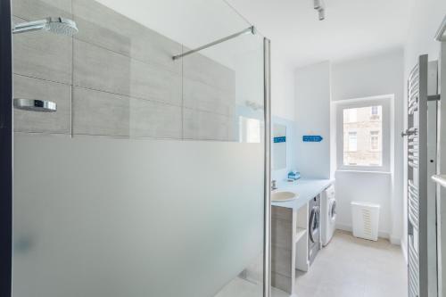 a white bathroom with a shower and a sink at Le Reef - Pépite dans l'Intramuros in Saint Malo