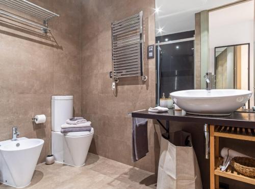 a bathroom with a sink and a toilet and a mirror at Cibeles I in Madrid