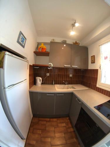 une cuisine avec un réfrigérateur blanc et un évier dans l'établissement Marina OPortoDuCap, au Cap d'Agde