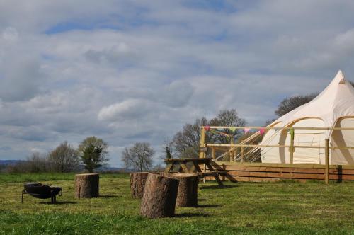 a tent and a picnic table in a field at Lovely spacious lotus bell tent in Shaftesbury UK in Shaftesbury