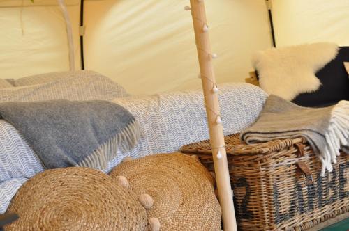 a room with a tent with blankets and a basket at Lovely spacious lotus bell tent in Shaftesbury UK in Shaftesbury