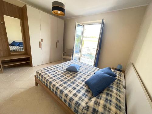 a bedroom with a bed with blue pillows on it at Costa Paestum Apartment in Paestum