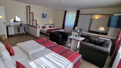 a hotel room with two beds and a television at Hotel Rhöner Land Garni - Bed & Breakfast in Oberthulba
