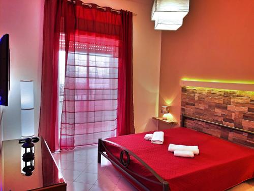 a bedroom with a red bed with towels on it at Casa Vacanza nel cuore di Castellammare del golfo in Castellammare del Golfo