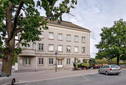 un gran edificio blanco con un camión delante en Pärnu Rüütli Apartments, en Pärnu
