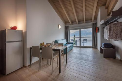 kuchnia i jadalnia ze stołem i lodówką w obiekcie Residence Solei Classic & Plus w Brenzone sul Garda