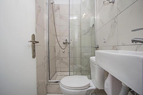 a white toilet sitting next to a shower in a bathroom at San Georgio Boutique Hotel by Hotelius in Agios Georgios Pagon
