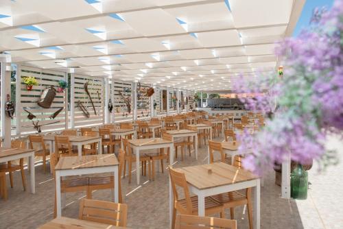 an empty restaurant with wooden tables and chairs at Hotel Club Eloro in Noto Marina