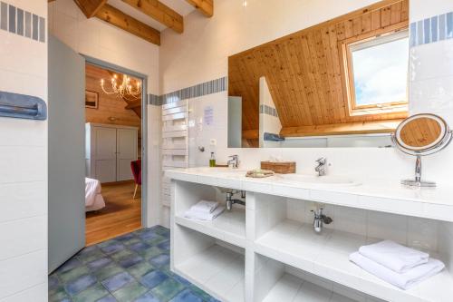 a bathroom with two sinks and a mirror at La Désirade - Hôtel, Spa & Restaurant in Bangor