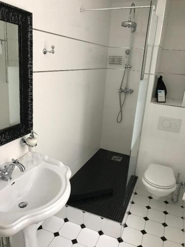 a white bathroom with a sink and a toilet at Le Grand Hôtel Mont Dore in Le Mont-Dore