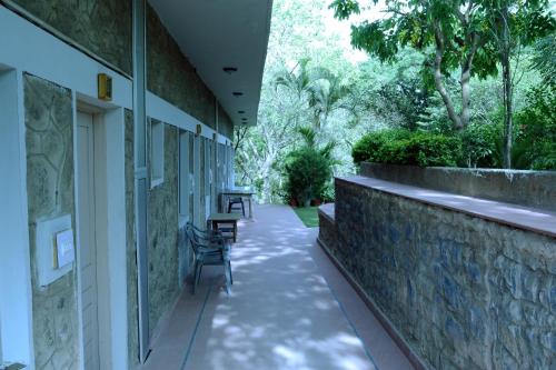 a walkway with chairs and tables on a building at Rising Sun Retreat in Mount Ābu