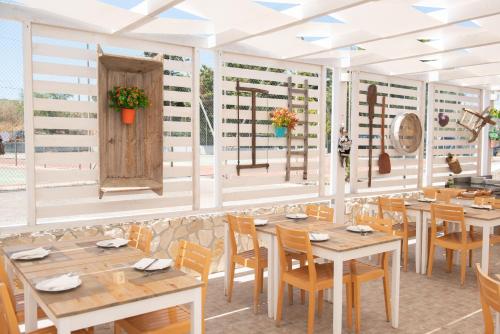 a dining room with wooden tables and chairs at Hotel Club Eloro in Noto Marina