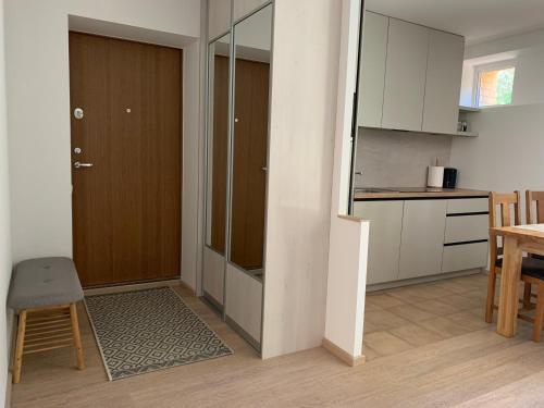 a kitchen and dining room with a door and a table at Pilkopė in Nida