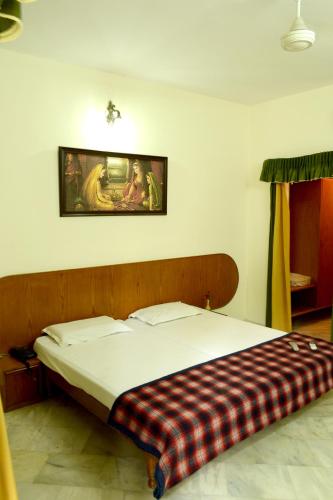 a bed in a bedroom with a plaid blanket on it at Rising Sun Retreat in Mount Ābu
