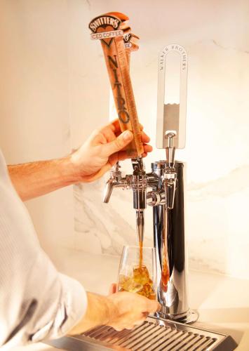 a man is filling a glass in a kitchen mixer at Grand Hyatt Nashville in Nashville