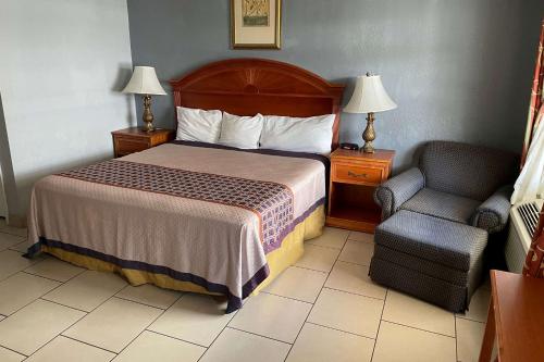 a hotel room with a bed and a chair at Travelodge by Wyndham Venice in Venice