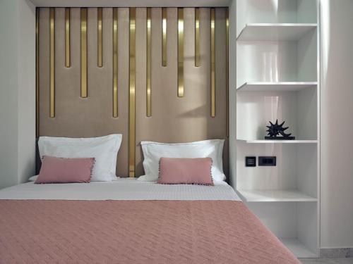 a bedroom with a bed with two pink pillows at SAVVAS & JOANNA BOUTIQUE in Laganas