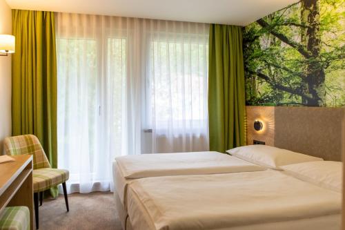een hotelkamer met 2 bedden en een raam bij Hotel garni Grundmühle in Bad Schandau