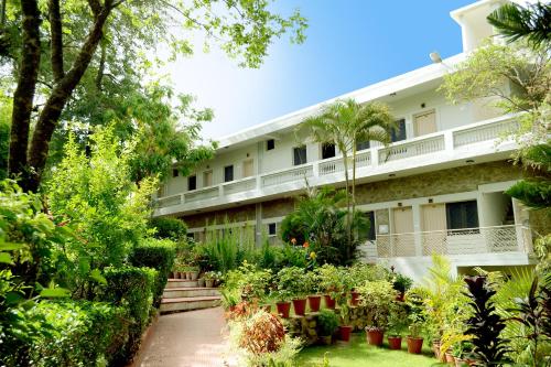 an exterior view of a building with plants at Rising Sun Retreat in Mount Ābu
