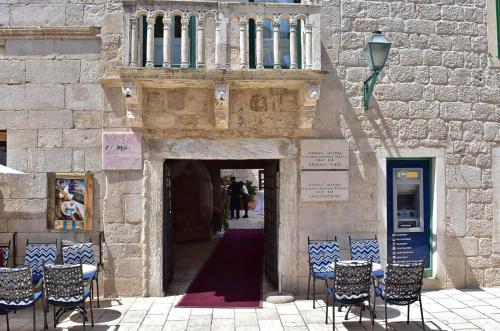 an entrance to a building with chairs and a doorway at Apartment Palace in Rab