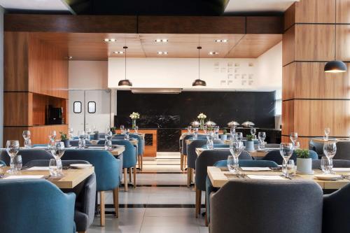 une salle à manger avec des tables, des chaises et un tableau noir dans l'établissement NH Mexico City Valle Dorado, à Mexico