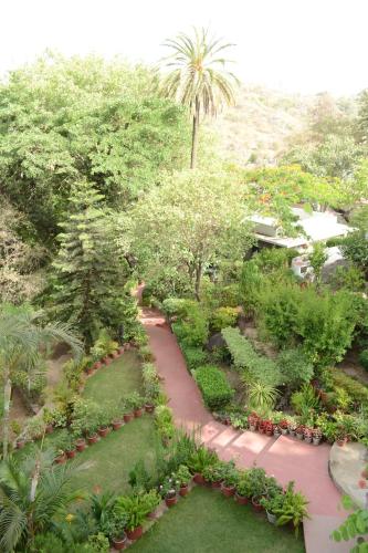 a walkway in a garden with plants and trees at Rising Sun Retreat in Mount Ābu