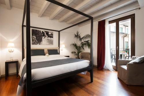 トッリ・デル・ベーナコにあるHotel Del Portoのベッドルーム(天蓋付きベッド1台付)、リビングルーム