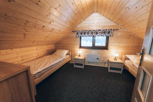 シュチルクにあるPolana Sucheの木造キャビン内のベッド2台が備わる部屋