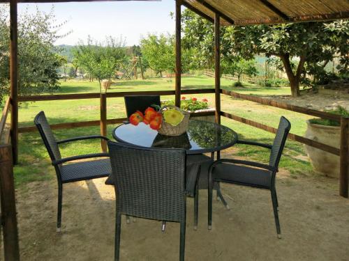 a table with chairs and a bowl of fruit on it at Apartment Il Ghiro by Interhome in Montechiaro dʼAsti