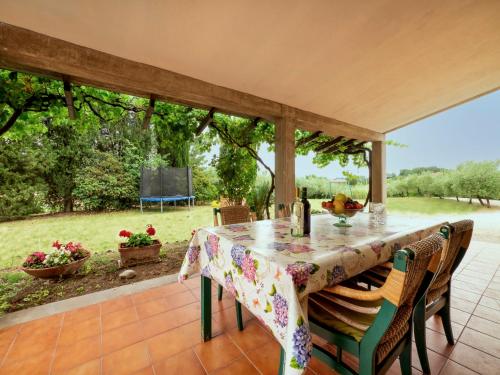 a table on a patio with a view of a garden at Holiday Home La Pergola by Interhome in Montemaggiore al Metauro