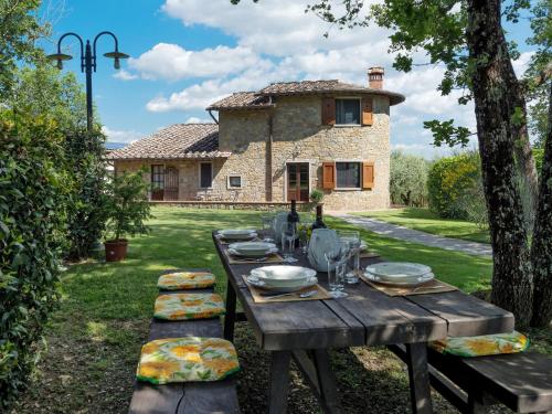 a wooden table in front of a stone house at Holiday Home Villa del Poggio by Interhome in Radda in Chianti