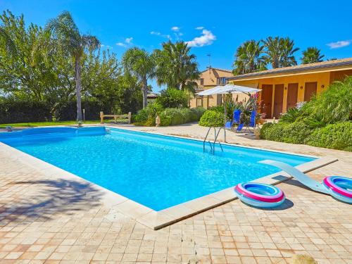 a swimming pool with two frisbees next to a house at Villa Bel Villa by Interhome in Marinella di Selinunte